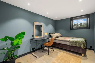 a bedroom with a bed and a desk and a mirror at Grand Junior Suite in Molde