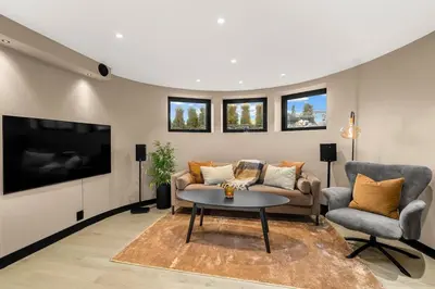 a living room with a couch and a table and a tv at Grand Junior Suite in Molde