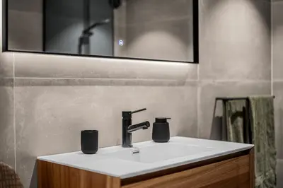 a bathroom with a sink and a mirror at Grand Junior Suite in Molde
