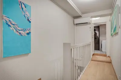 a hallway with white walls and a blue painting on the wall at 3 soverom, sentralt i Bergen og moderne bad in Bergen