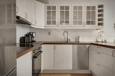 a white kitchen with white cabinets and a sink at 3 soverom, sentralt i Bergen og moderne bad in Bergen