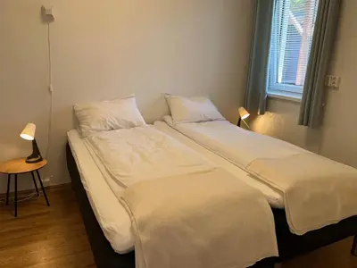 a bedroom with two beds with white sheets and a window at 4 person holiday home in Eidsvåg in Eidsvåg