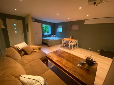 a living room with a couch and a table at Koselig, ny 1-roms hybelleilighet med moderne kjøkken in Stord