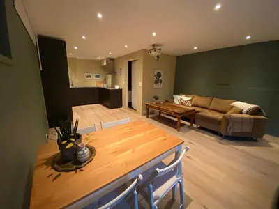 a living room with a table and a couch at Koselig, ny 1-roms hybelleilighet med moderne kjøkken in Stord
