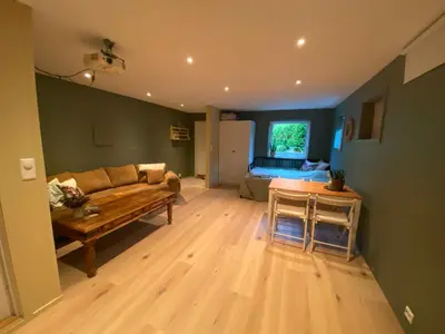 a living room with a couch and a table at Koselig, ny 1-roms hybelleilighet med moderne kjøkken in Stord