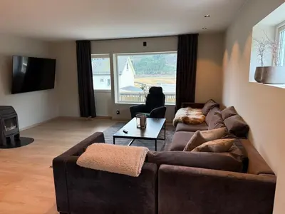 a living room with two couches and a large window at Nyoppusset leilighet til leie in Isfjorden