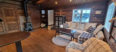 a living room with a couch and a table at Krøderen Laftet tømmerstue fra 2021