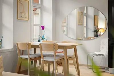 a dining room with a table and chairs and a mirror at Perfect Location by Bryggen in Bergen