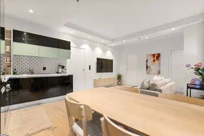 a kitchen and living room with a large wooden table at Perfect Location by Bryggen in Bergen