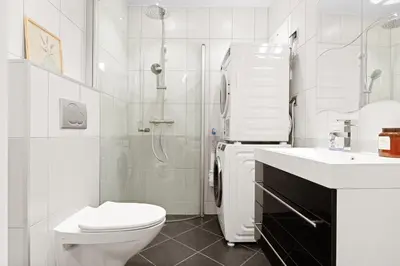 a white bathroom with a toilet and a shower at Perfect Location by Bryggen in Bergen