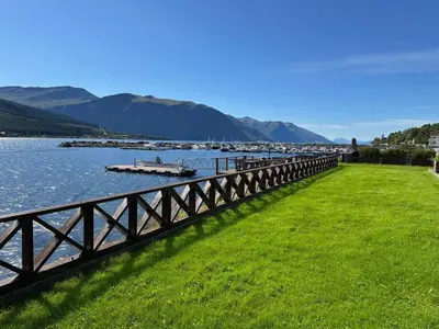 a bridge over a river with a boat in the water at 4 star holiday home in Eidsvåg in Eidsvåg