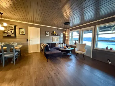 a living room with a couch and a table at Unique view! Modern apartment with sauna in Vossevangen