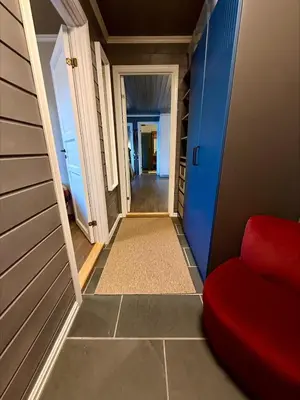 a hallway with a red chair and blue walls at Unique view! Modern apartment with sauna in Vossevangen