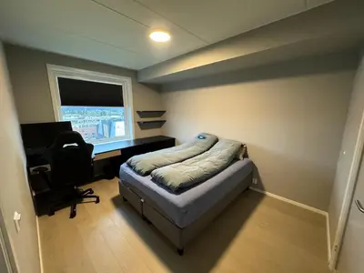 a bedroom with a bed and a desk and a computer at Family-friendly luxury penthhouse with three bedrooms in Stjoerdal