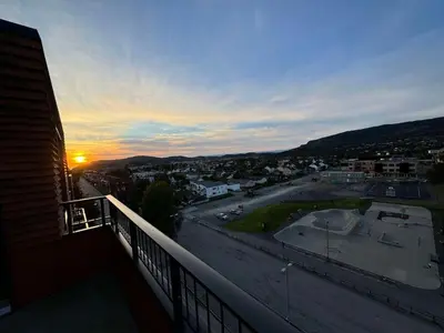 a view of the sunset from a balcony of a building at Family-friendly luxury penthhouse with three bedrooms in Stjoerdal