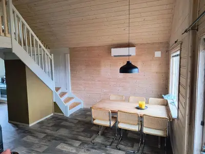 a dining room with a table and chairs and a staircase at Ullabu in Gol