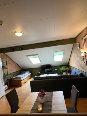 a living room with a couch and a table at Leilighet I låve in Gran