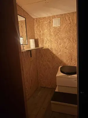 a small bathroom with a toilet and a sink at Torshaug glamping in Trondheim