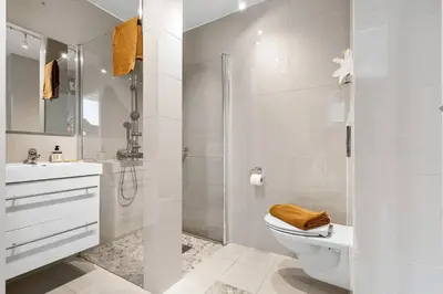 a white bathroom with a toilet and a shower at Cozy 2-bedroom apartment near Bergen City Centre in Bergen