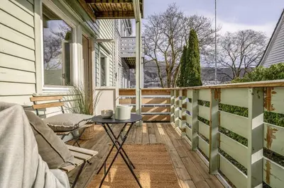 a balcony with a table and chairs on a house at Cozy 2-bedroom apartment near Bergen City Centre in Bergen