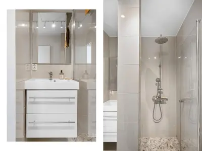 a white bathroom with a shower and a sink at Cozy 2-bedroom apartment near Bergen City Centre in Bergen