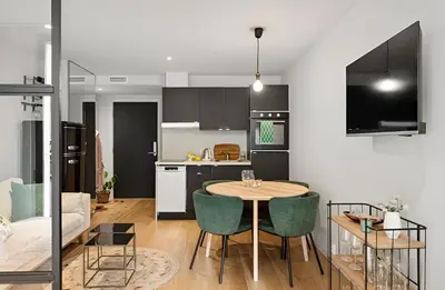 a kitchen and living room with a table and chairs at Studio apartment in city center in Bergen