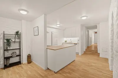 a kitchen with white walls and a wooden floor at Bergen city center Kalfaveien in Bergen