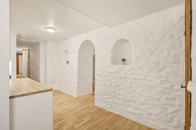 a kitchen with white walls and wooden floors at Bergen city center Kalfaveien in Bergen