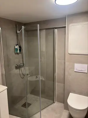 a shower stall in a bathroom with a toilet at Family friendly apartment with parking in Bergen