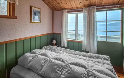 a bed in a room with a large window at Nice Home In Vallavik With Wifi in Kaland