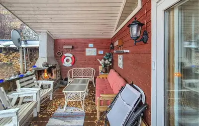 a small patio with a table and a fireplace at Nice Home In Vallavik With Wifi in Kaland