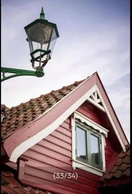 a red house with a street light on top of it at Sentralt,unikt lite bergenshus med sjel på fine Nøstet! in Bergen