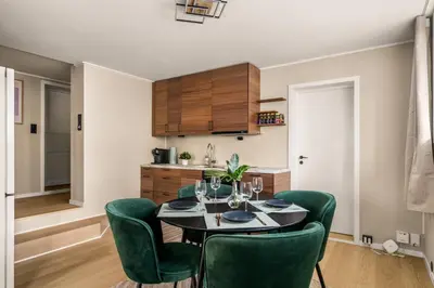a dining room with a table and green chairs at Bright & Stylish Apartment in City Center in Bergen
