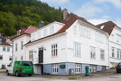 a green van parked in front of a white building at Bright & Stylish Apartment in City Center in Bergen