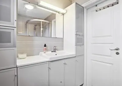 a white bathroom with a sink and a mirror at Your home in Kristiansund in Kristiansund