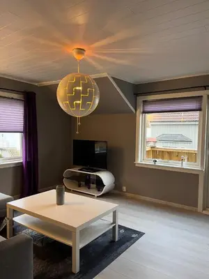 a living room with a table and a chandelier at Your home in Kristiansund in Kristiansund