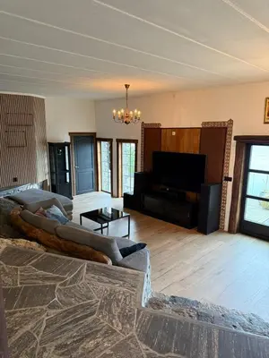 a living room with a large couch in a room with a television at Haven Fortress