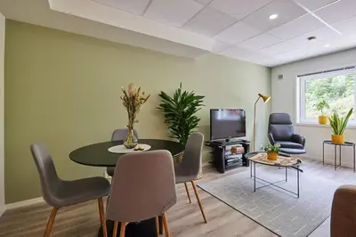 a living room with a table and chairs and a tv at Tasteful apartment in Sogndal with parking in Sogndal