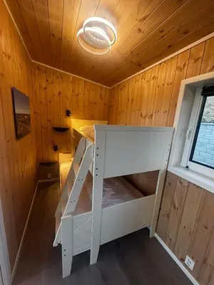 a small room with a white bed in a cabin at Unik og moderne hytte med utsikt mot havet 38 in Haram