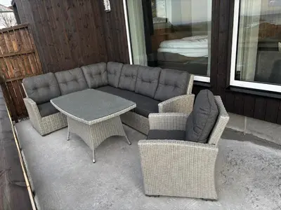 a couch and two chairs and a table on a porch at Unik og moderne hytte med utsikt mot havet 38 in Haram