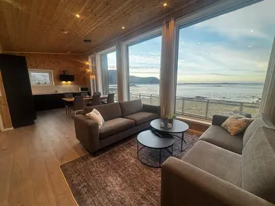 a living room with a couch and a large window at Unik og moderne hytte med utsikt mot havet 38 in Haram