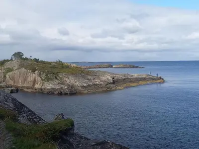 an island in the ocean with people on it at Unik og moderne hytte med utsikt mot havet 38 in Haram