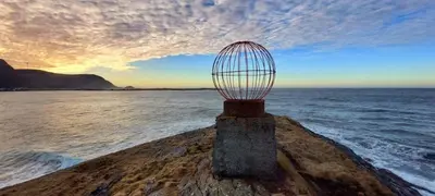 a bird cage on a rock in the ocean at Unik og moderne hytte med utsikt mot havet 38 in Haram