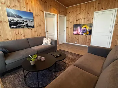 a living room with a couch and a table at Unik og moderne hytte med utsikt mot havet 38 in Haram