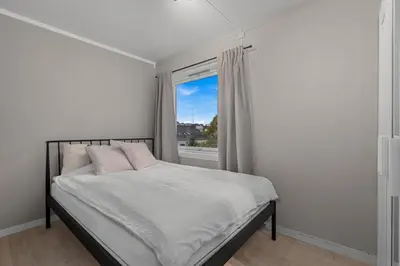 a white bedroom with a bed and a window at Apartment in idyllic Kristiansund in Kristiansund