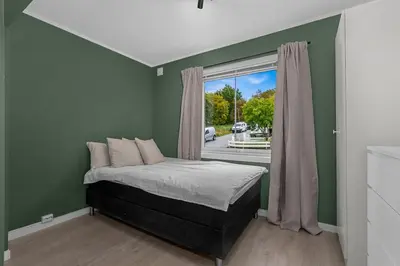 a bedroom with green walls and a bed with a window at Apartment in idyllic Kristiansund in Kristiansund