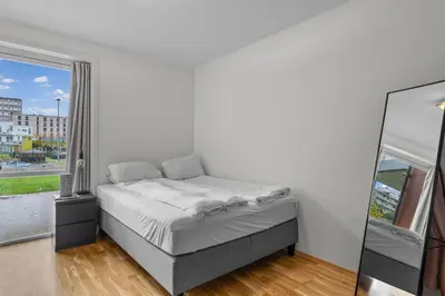 a bedroom with a bed and a large window at Convenient Bergen Stay with Easy Transport Connections in Bergen
