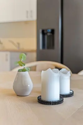 a table with a white vase and a plant on it at Convenient Bergen Stay with Easy Transport Connections in Bergen
