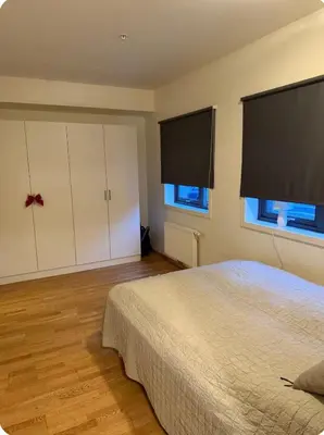 a bedroom with a large bed and two windows at Modern apartment near Oslo in Lii