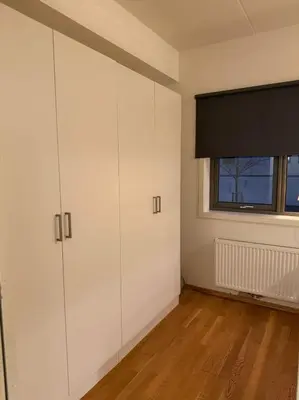 an empty room with white cabinets and a window at Modern apartment near Oslo in Lii